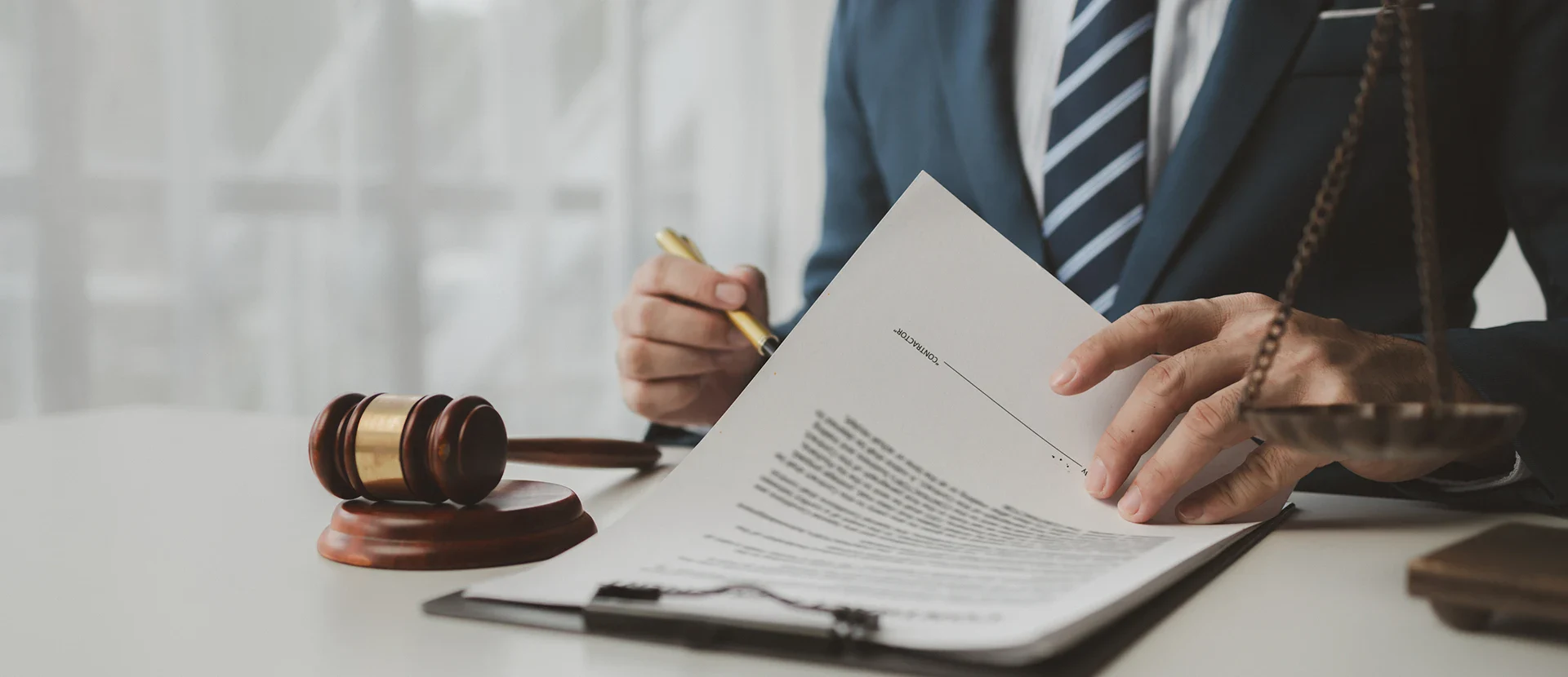 A lawyer in a suit writes notes on a legal document